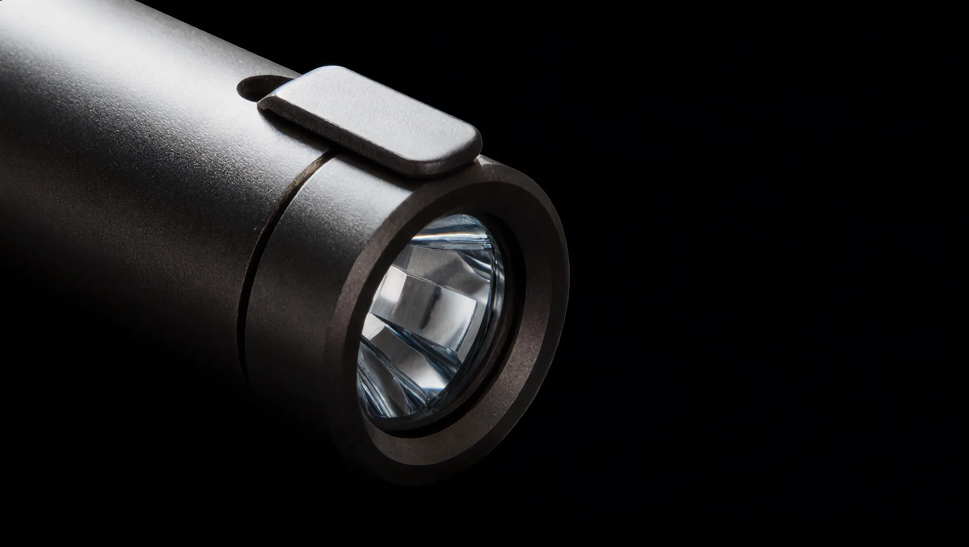 Macro of the head: the flat bezel and the glass lens over the reflector.